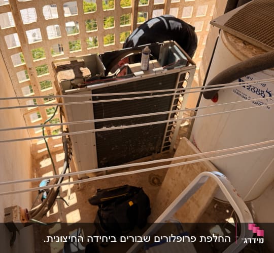 תיקון מזגן עם ציוד וכלים במרפסת